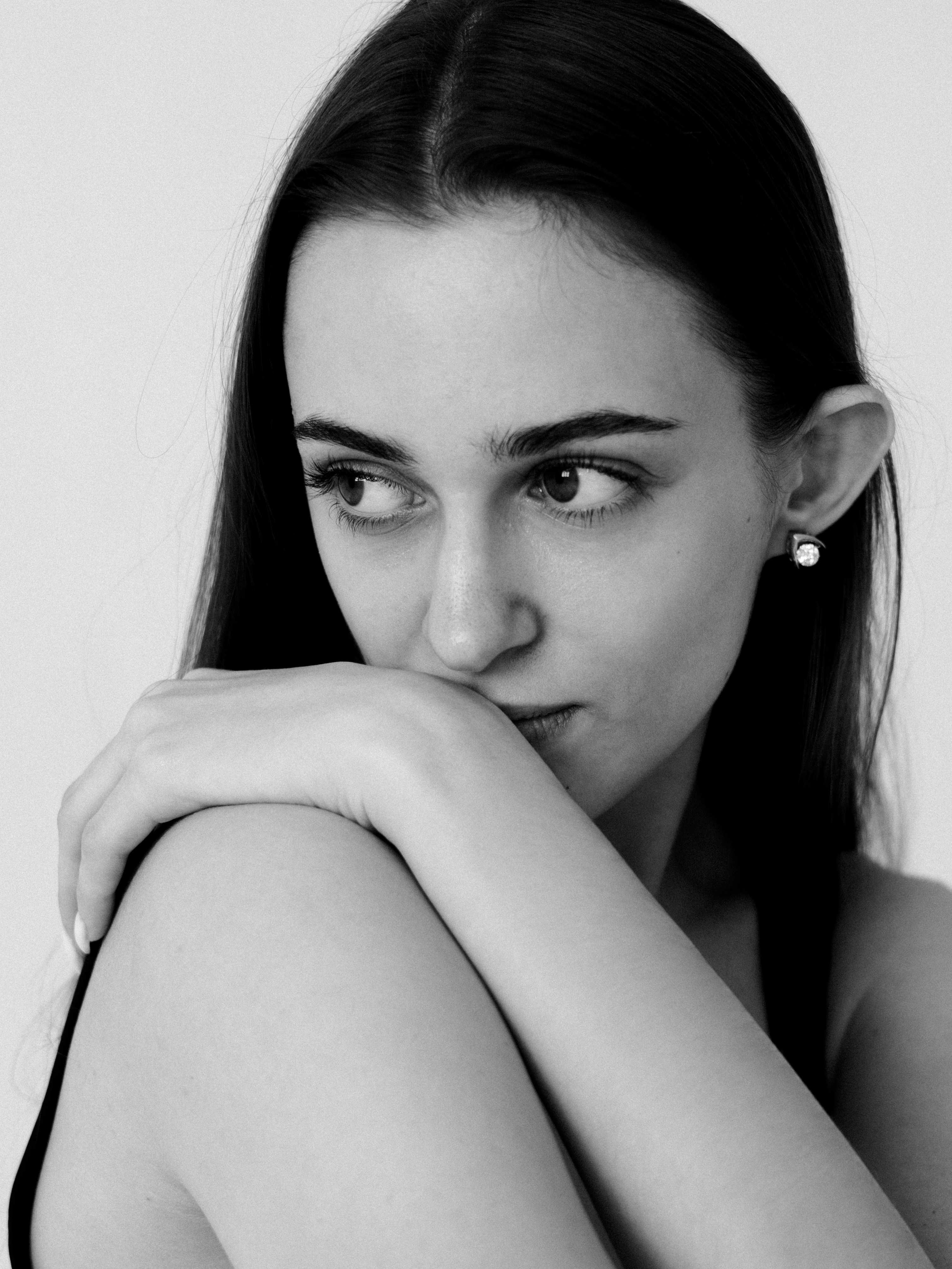 Черно-белый крупный портрет темноволосой женщины, опирающейся подбородком на руку